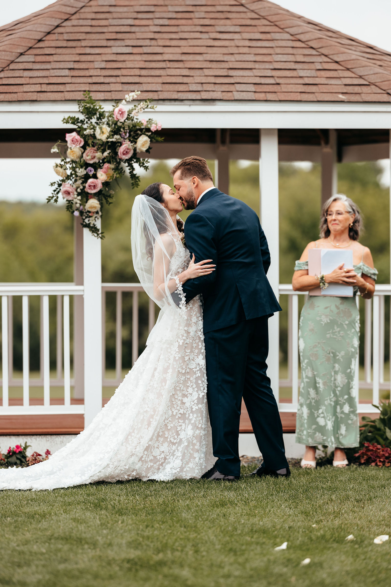 First kiss at the white gazebo with a pink and white floral arch at Dell-Lea in Chichester NH