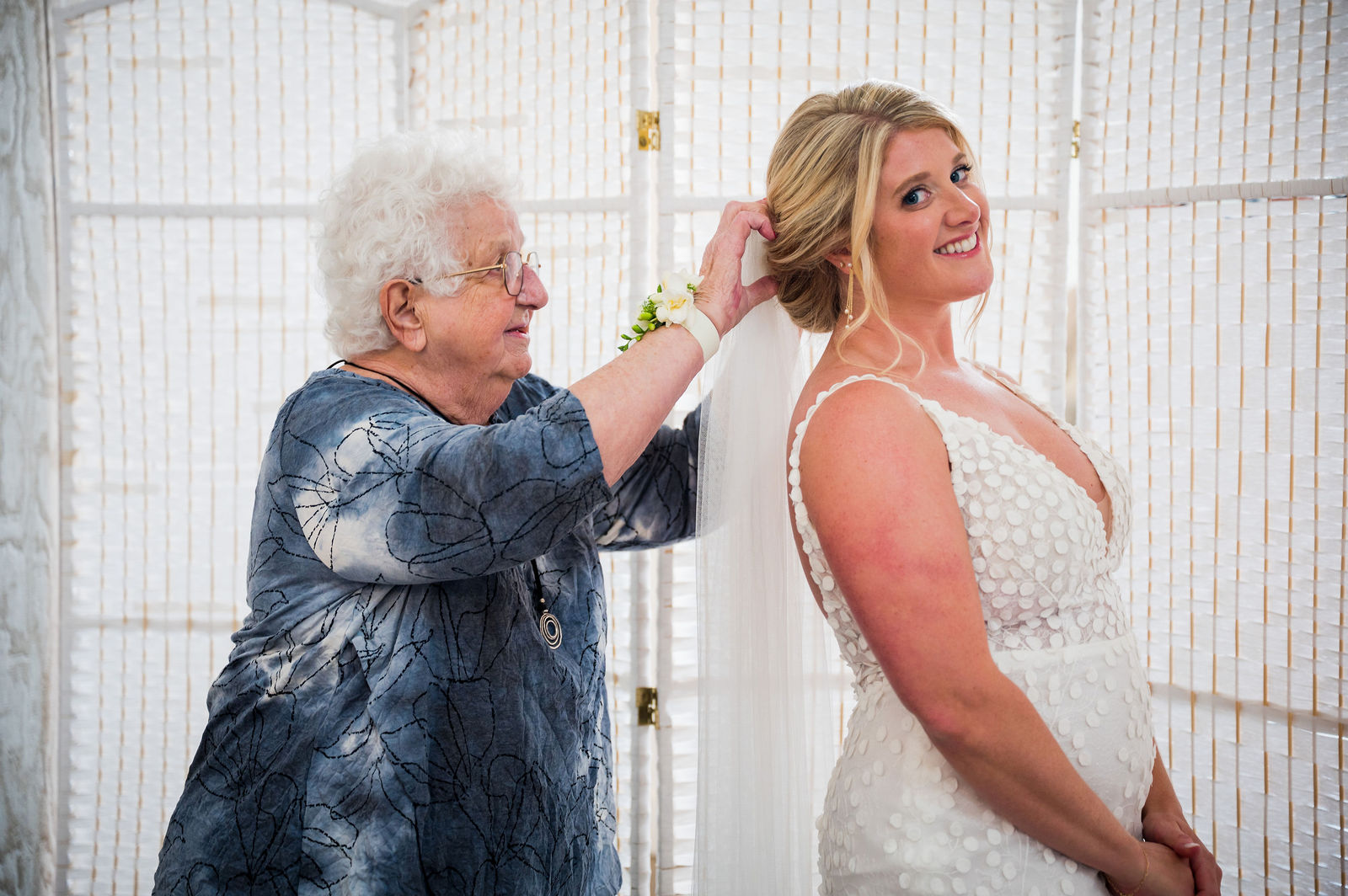Grandmother fastening the bride’s necklace before her Colorado wedding ceremony