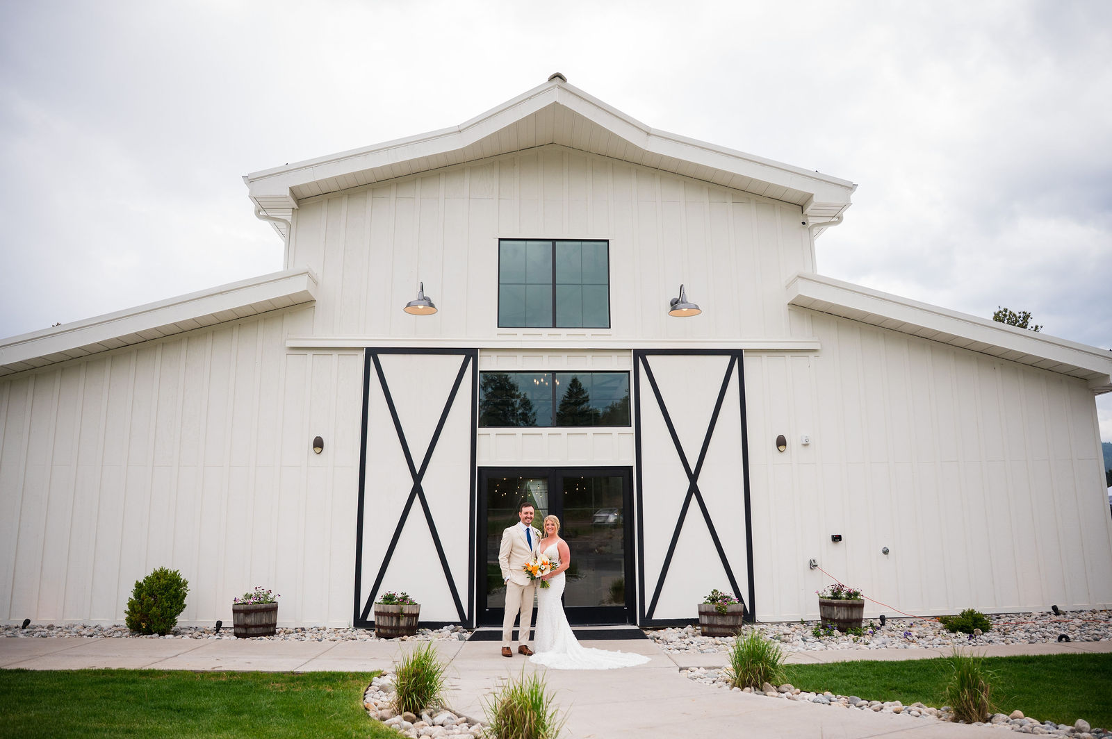 Bride and groom framed in the open barn doors at The Woodlands wedding venue in Morrison Colorado