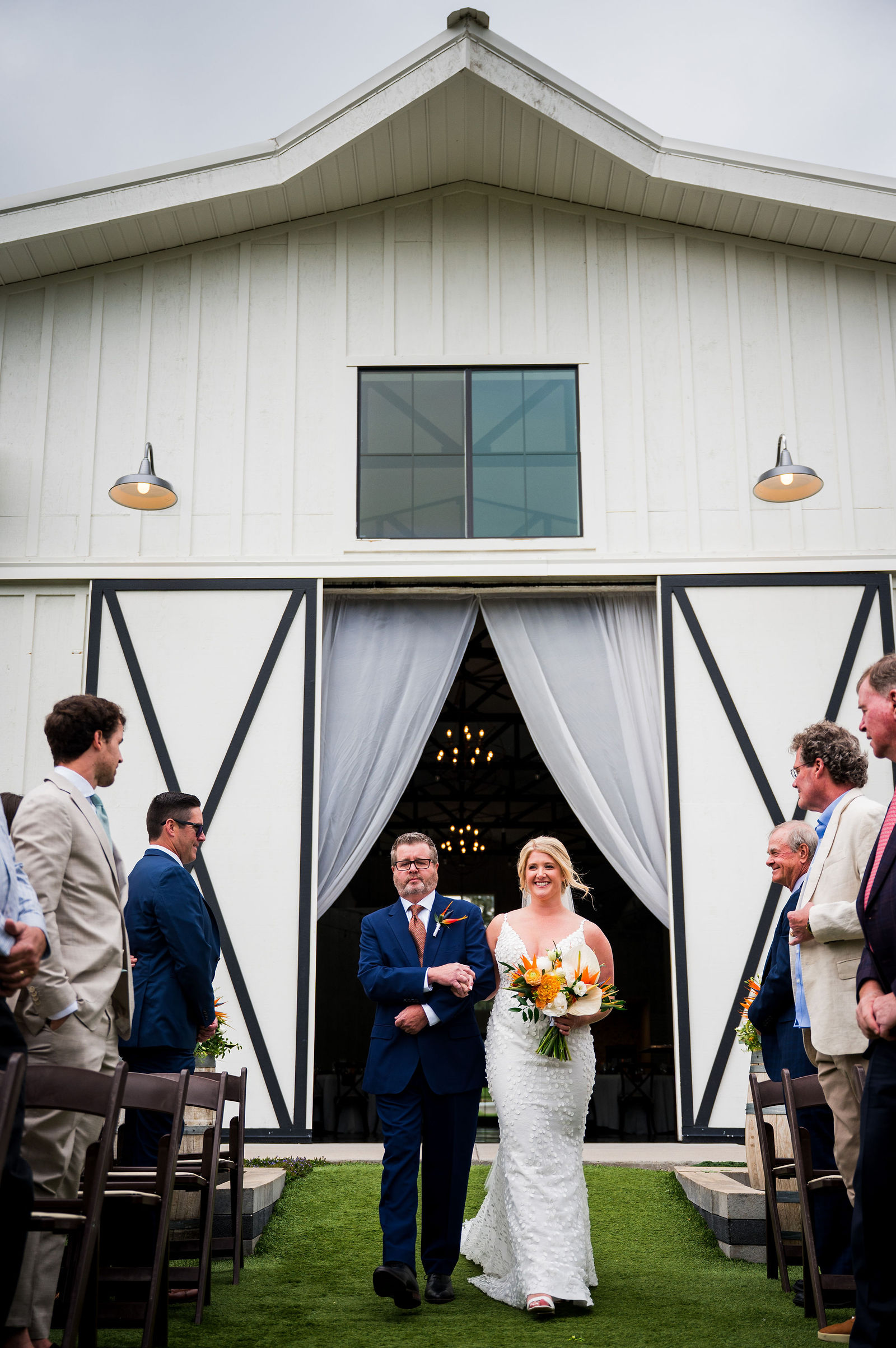 Bride and her father framed in the barn doors at The Woodlands wedding venue