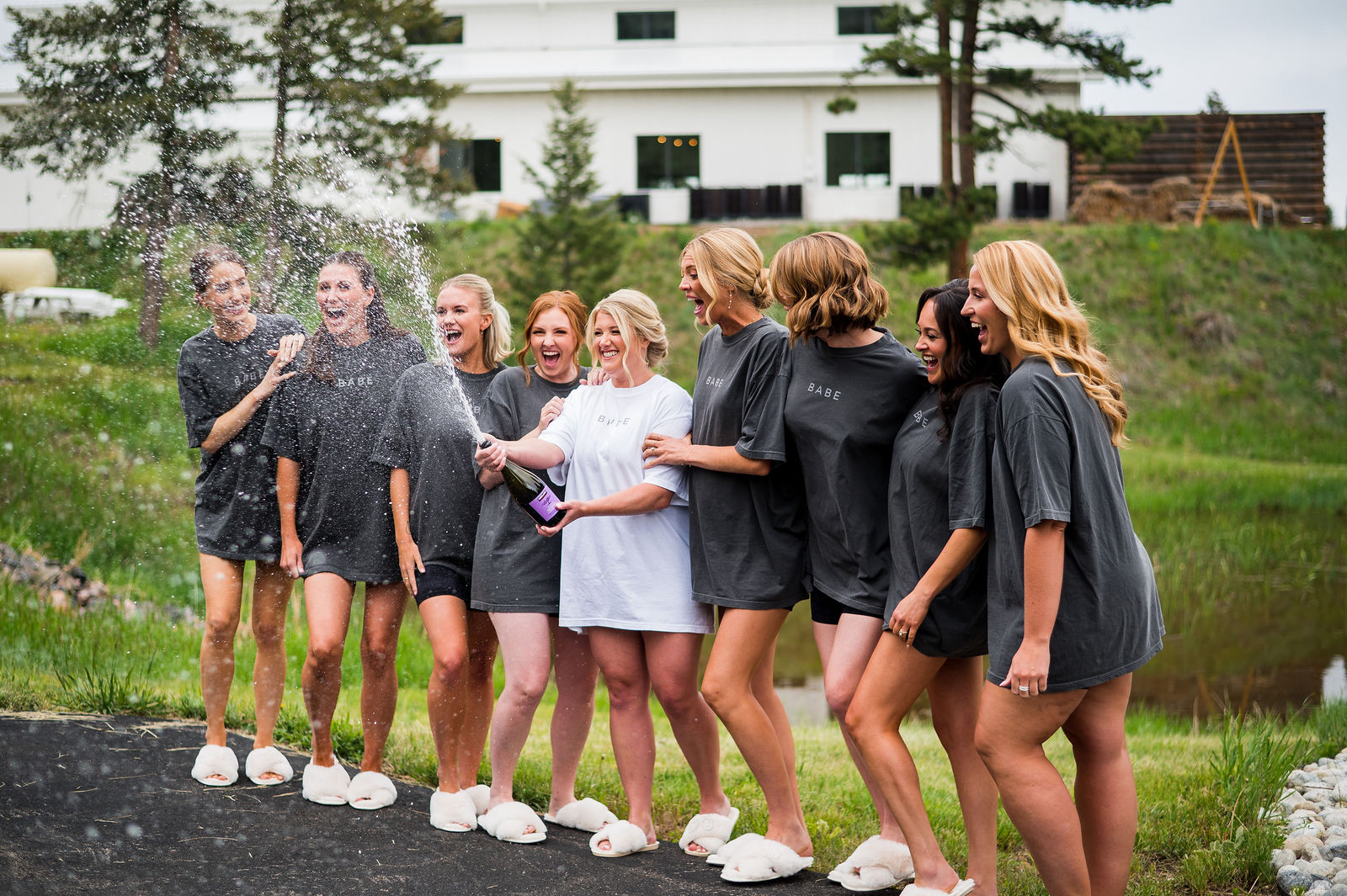 Bride and bridesmaids spraying champagne while getting ready in Golden Colorado