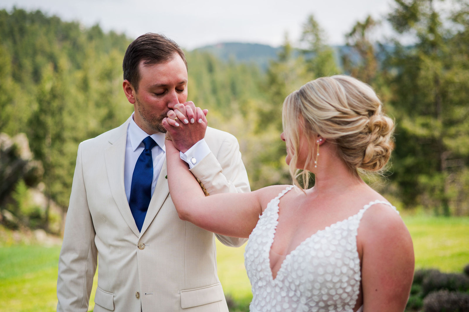 Bride touching the groom’s face during their first look in Morrison Colorado