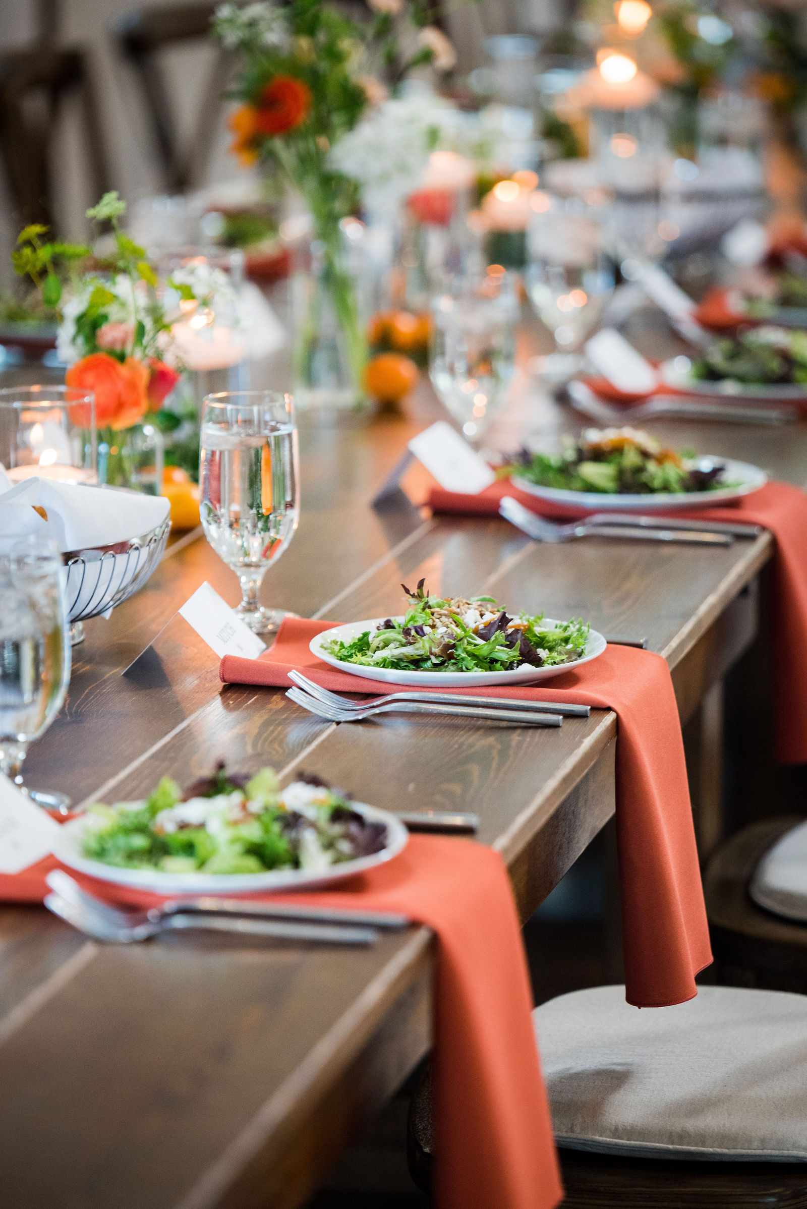 Place setting with a rust napkin at a Woodlands Colorado wedding reception