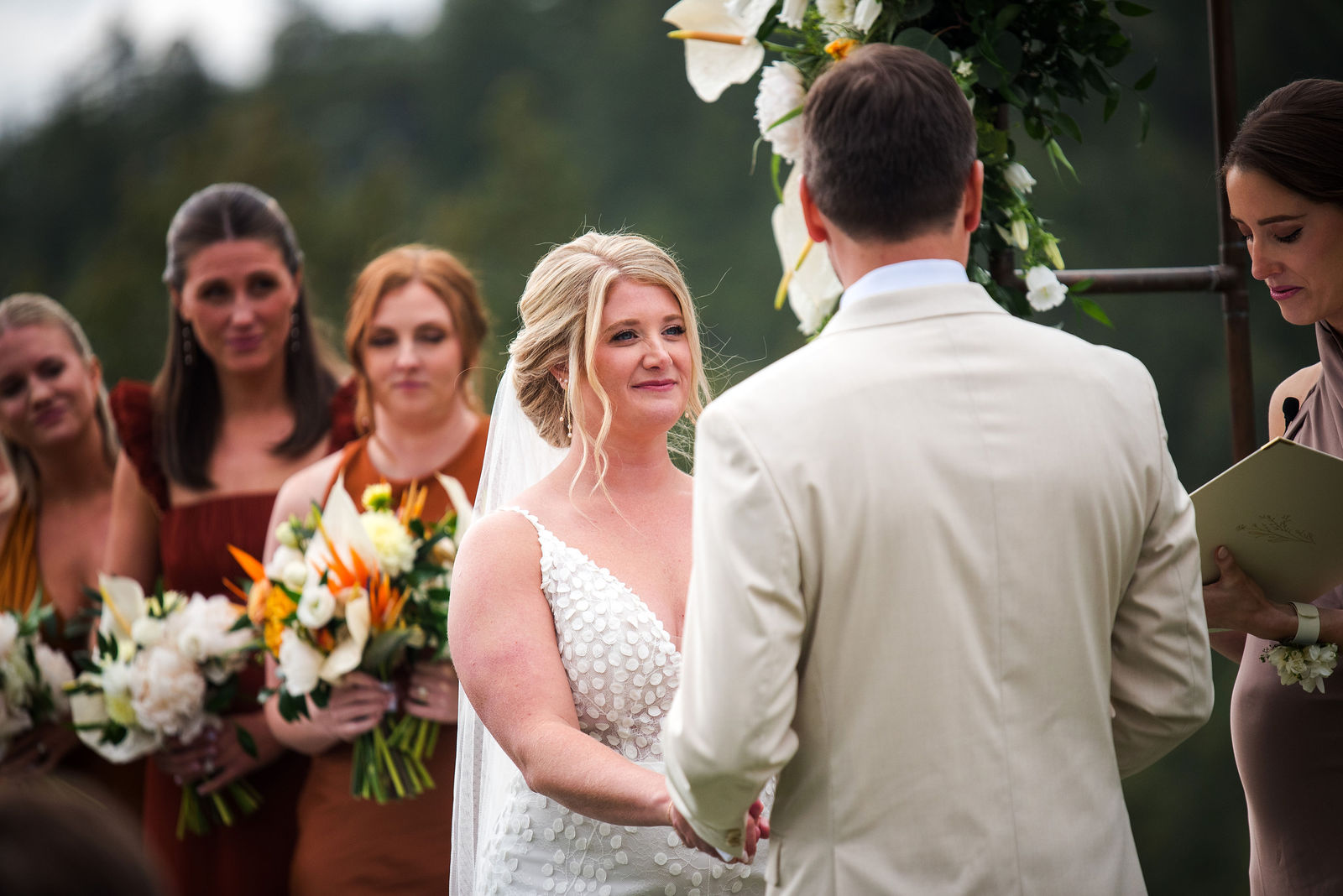 Bride and groom holding hands during their Colorado wedding ceremony