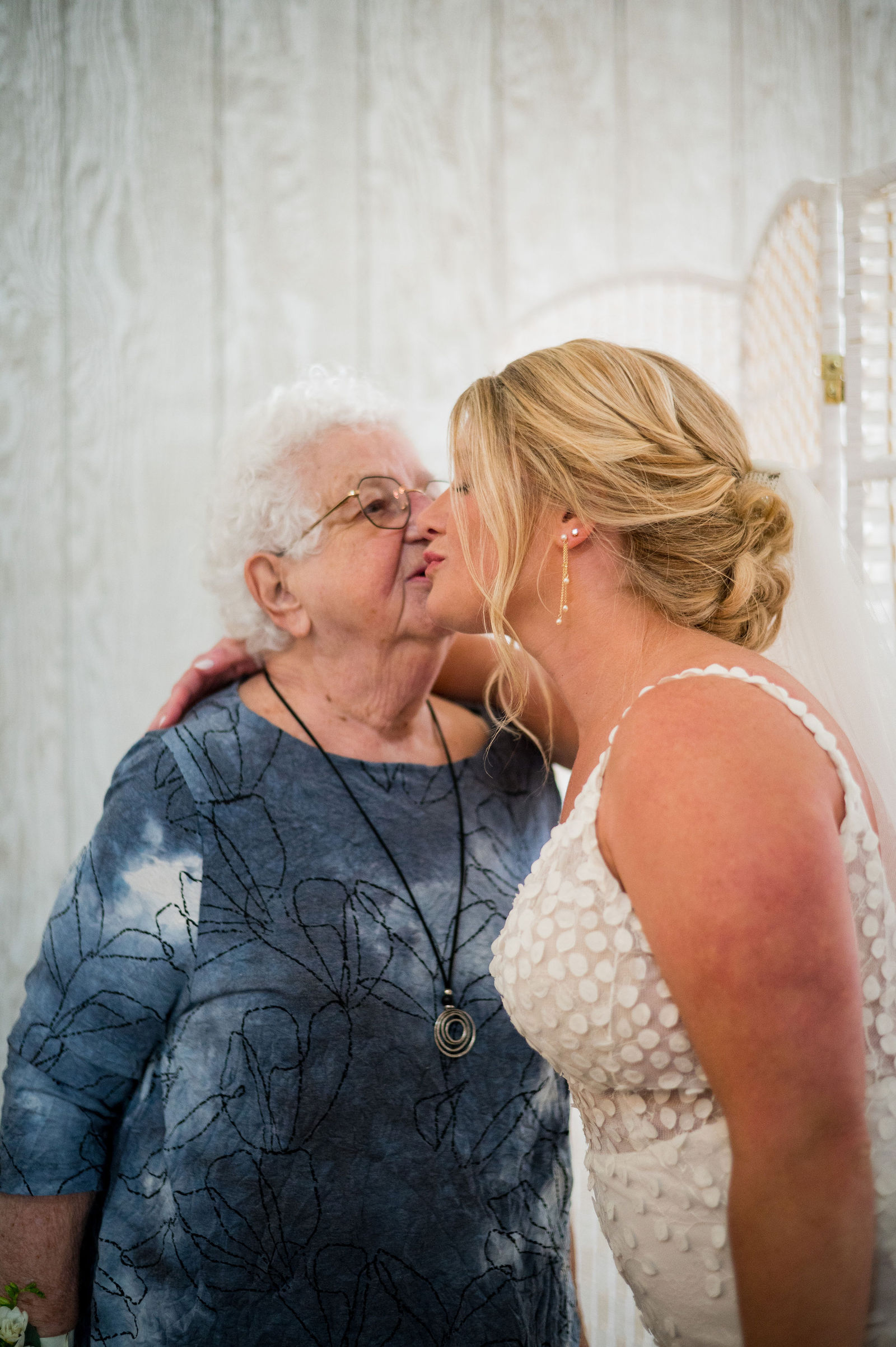 Grandmother kissing the bride on the cheek before a Woodlands Colorado wedding