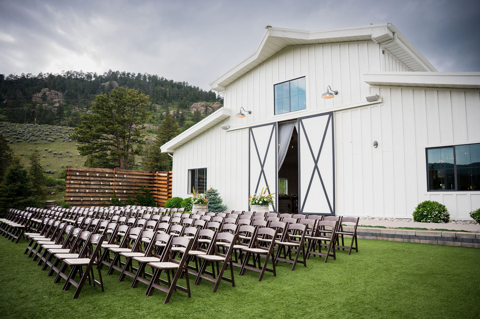 Outdoor ceremony setup beside the white barn at The Woodlands Colorado