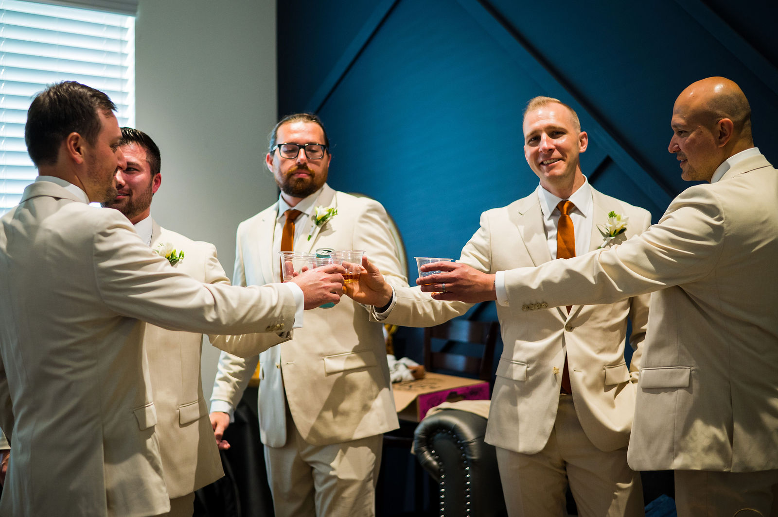 Groom and groomsmen raising a whiskey toast at The Woodlands in Morrison Colorado