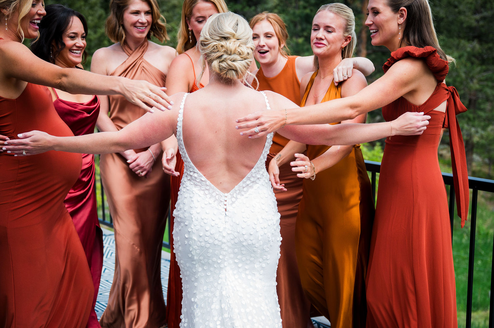 Bridesmaids reaching for the bride during her first look at The Woodlands Colorado
