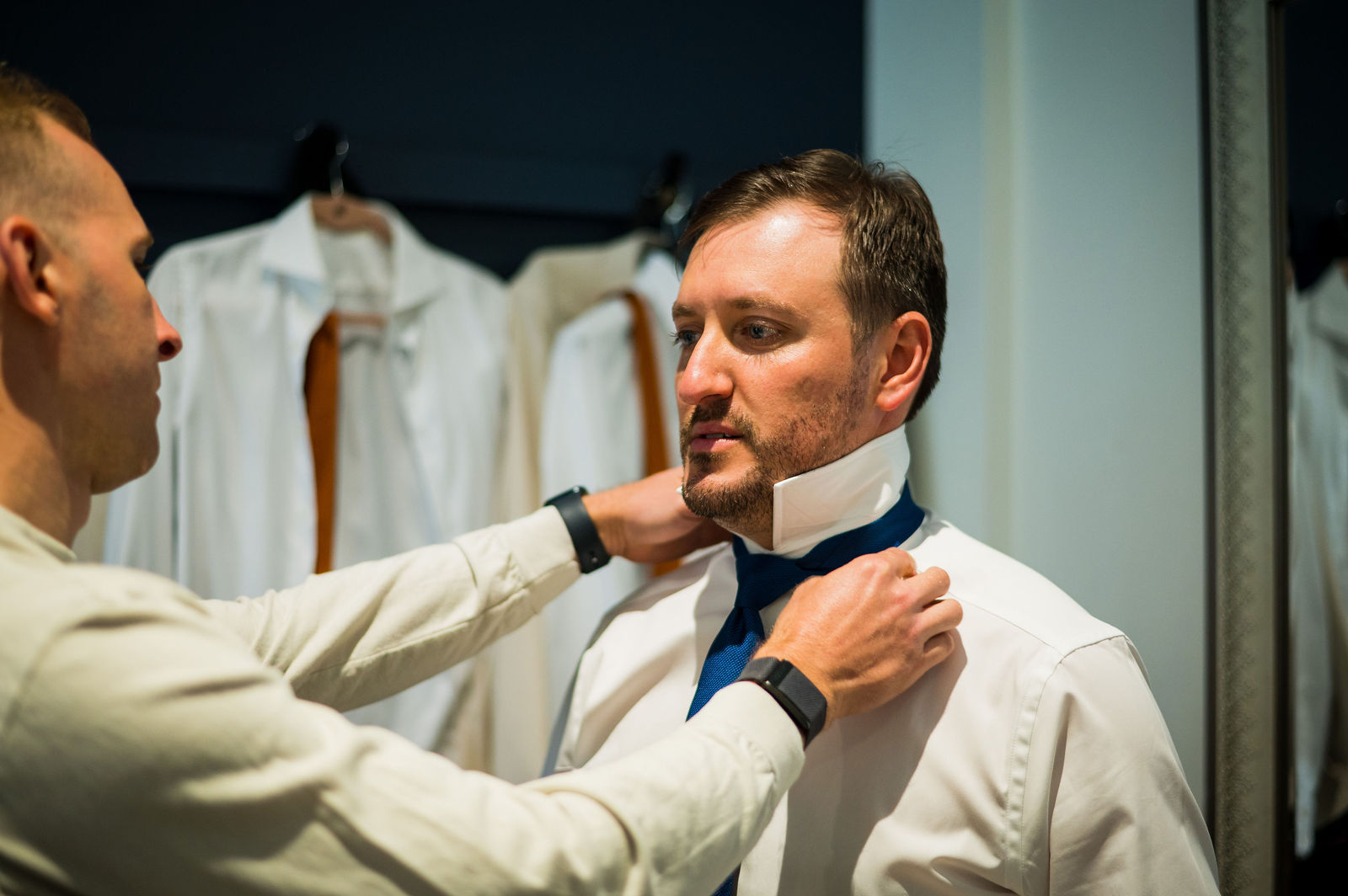 Groomsman helping the groom with his tie before a Morrison Colorado wedding