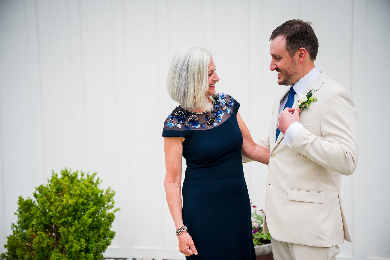 Mother of the groom straightening his jacket before a Colorado wedding