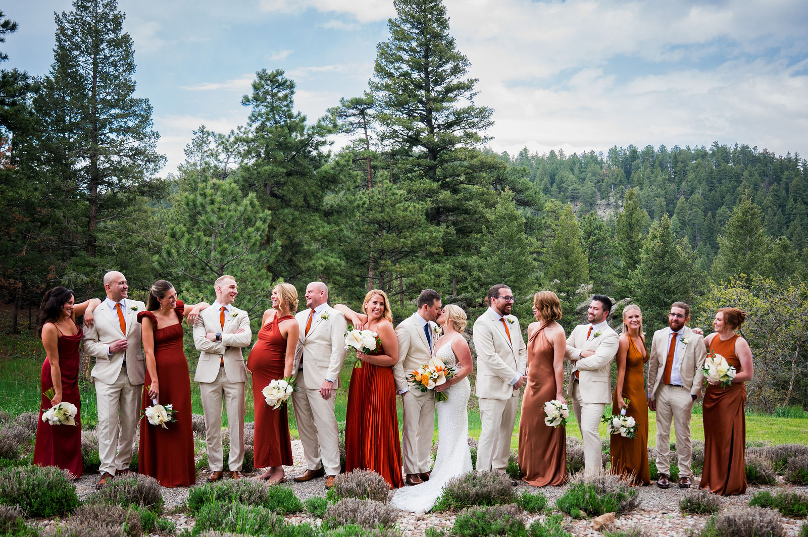 Full wedding party lined up in the pines at The Woodlands in Morrison Colorado