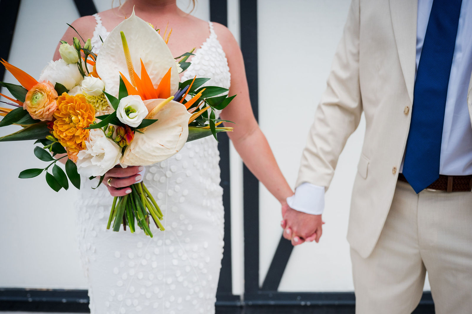 Bride and groom holding hands with a Bird of Paradise bouquet in Morrison Colorado