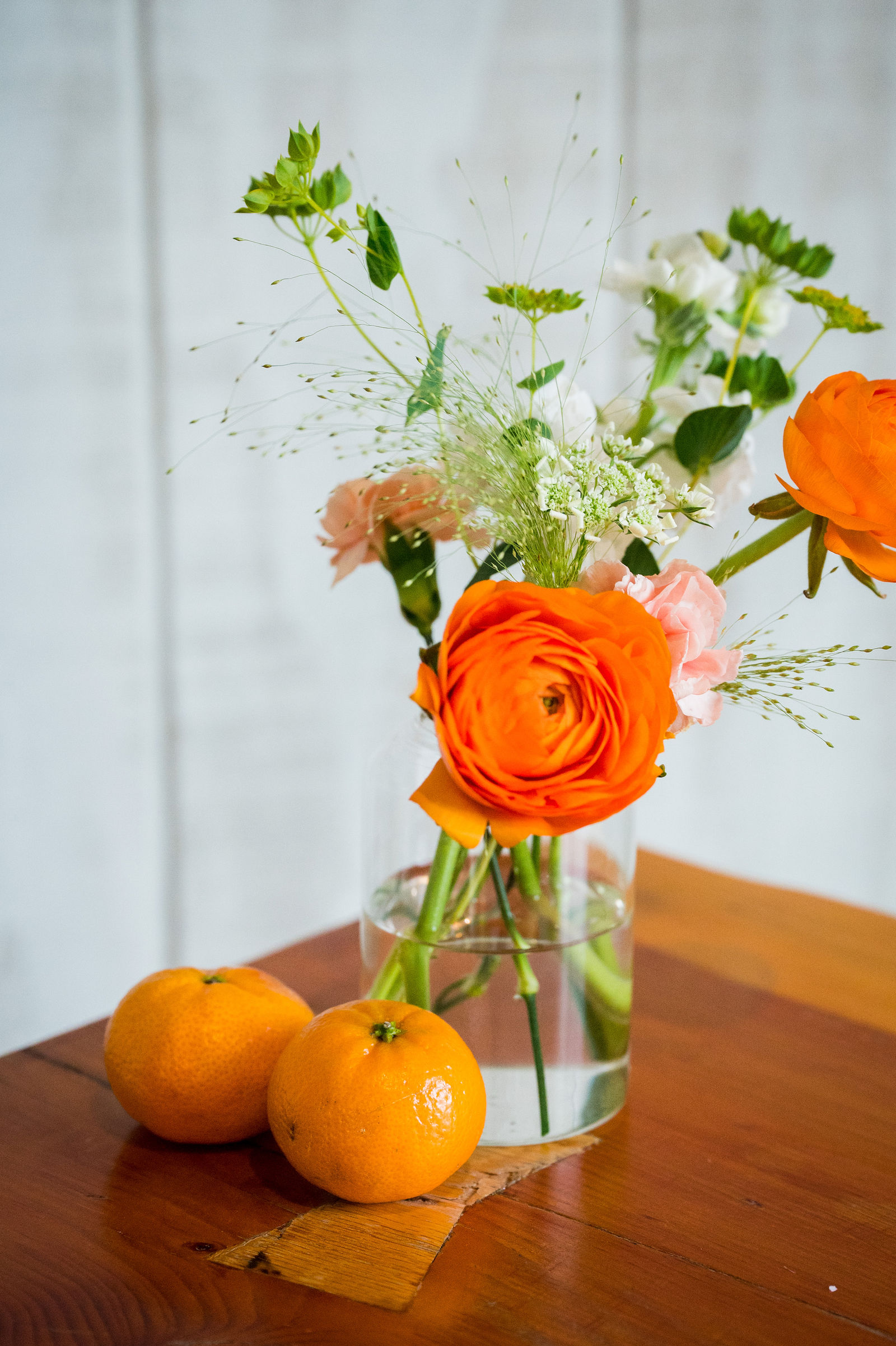 Orange ranunculus and oranges as wedding reception decor in Colorado