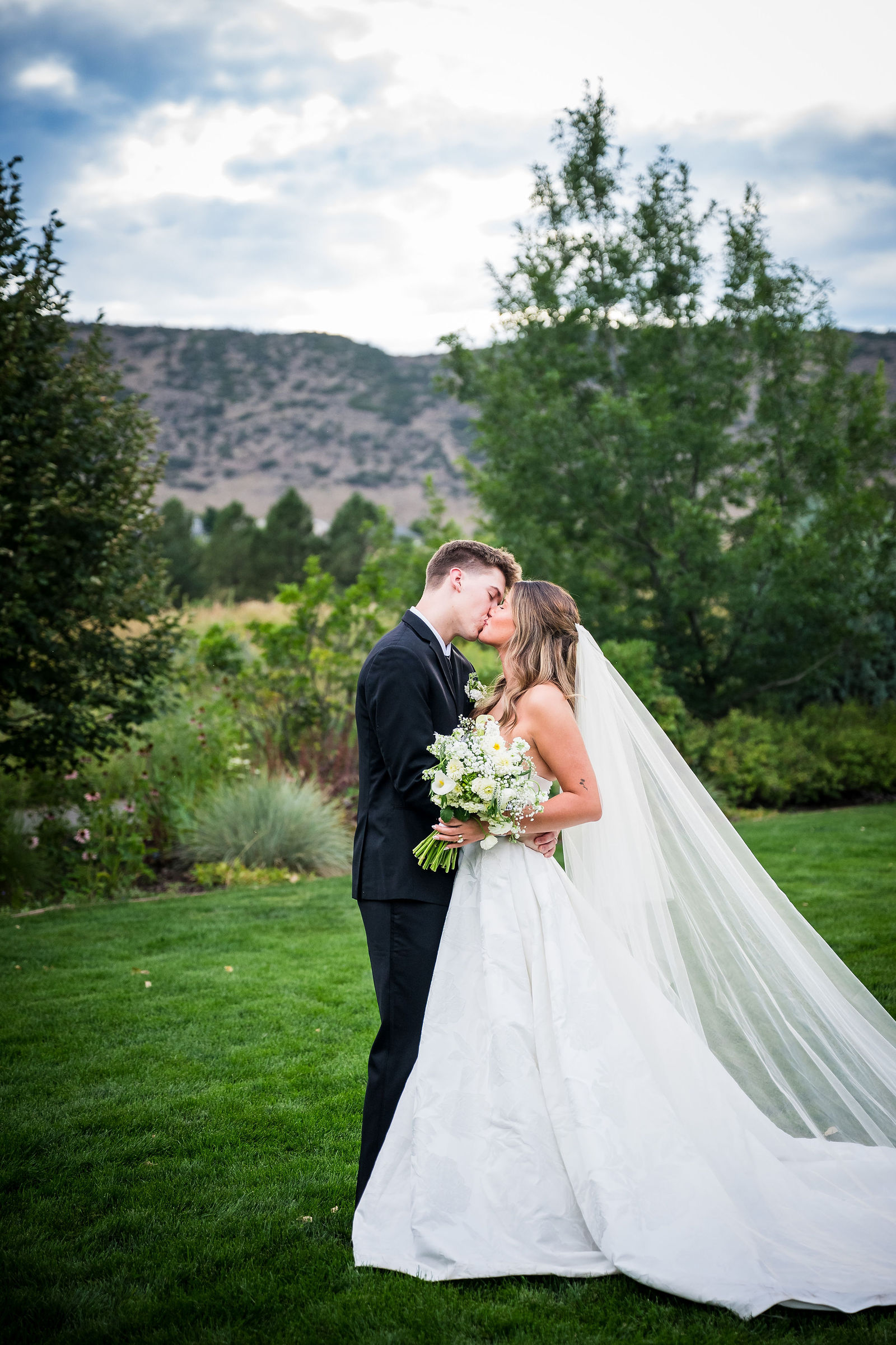 Bride and groom kissing under her veil