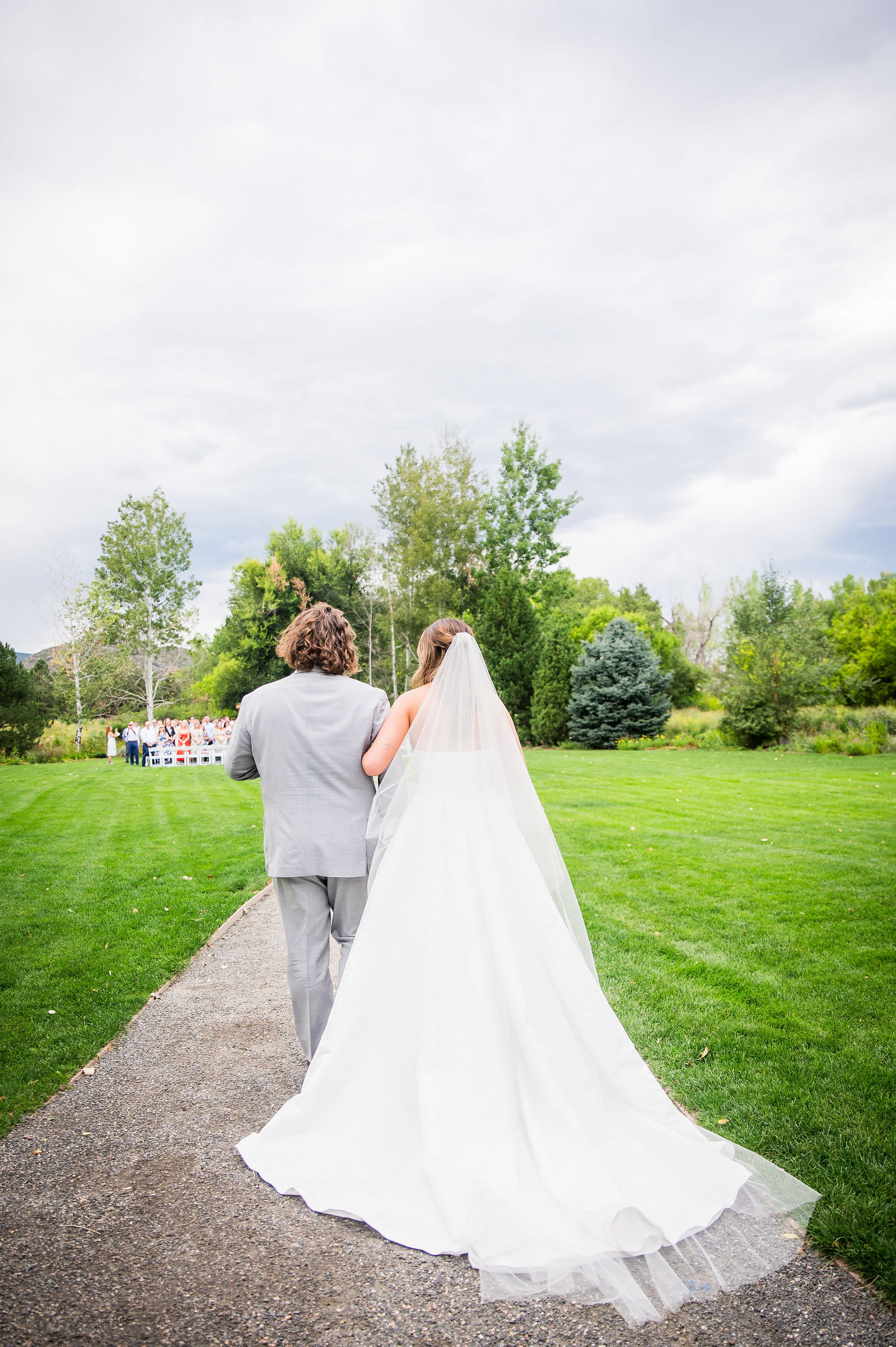 Bride walking down the aisle with a family friend at Chatfield Farms