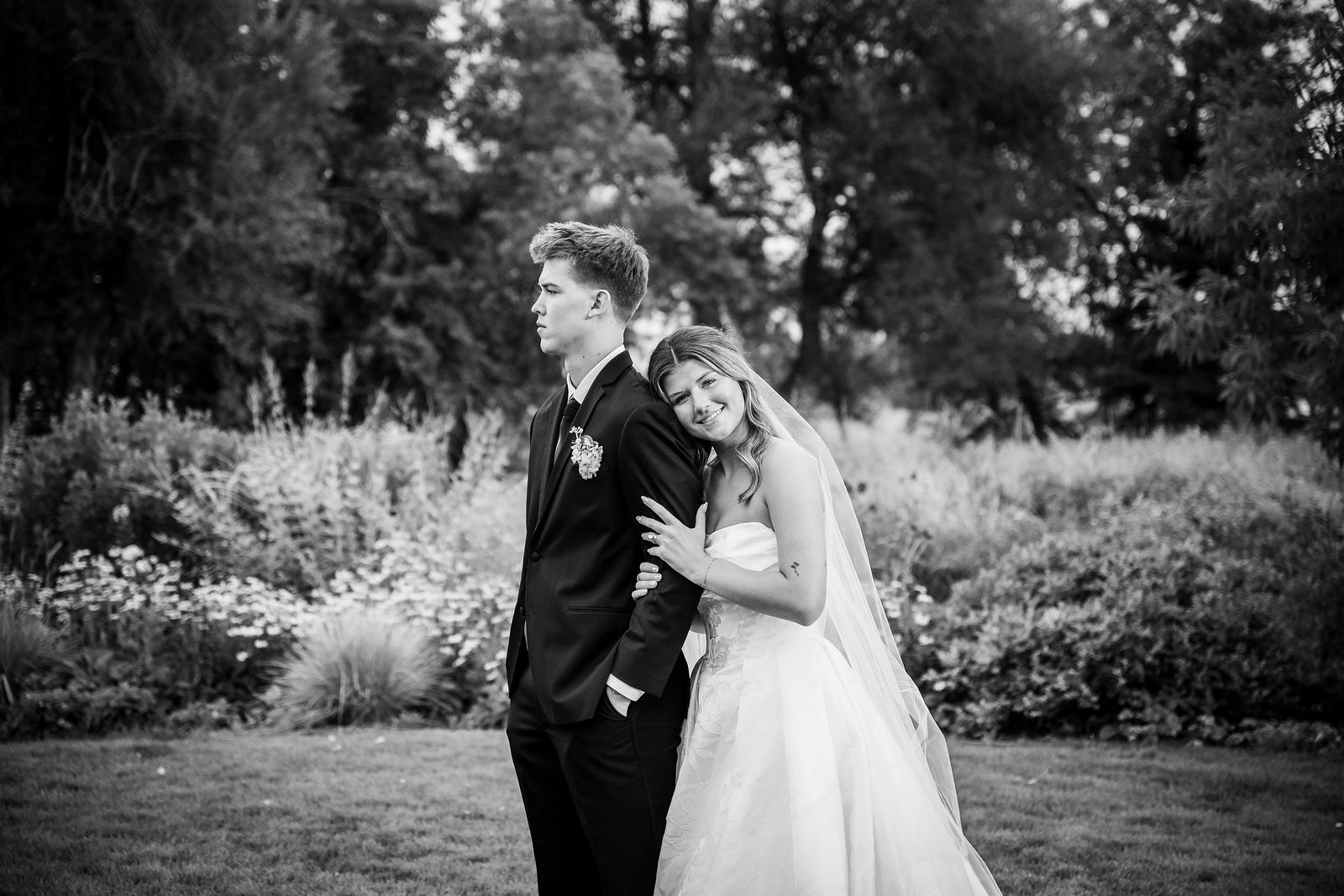 Groom dipping his bride in the field at sunset