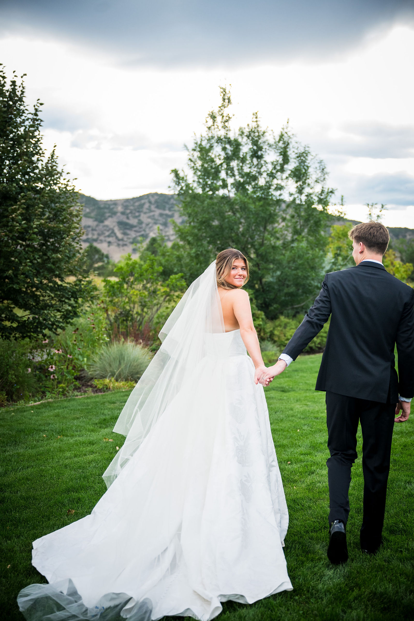 Bride and groom walking with the Colorado foothills behind them