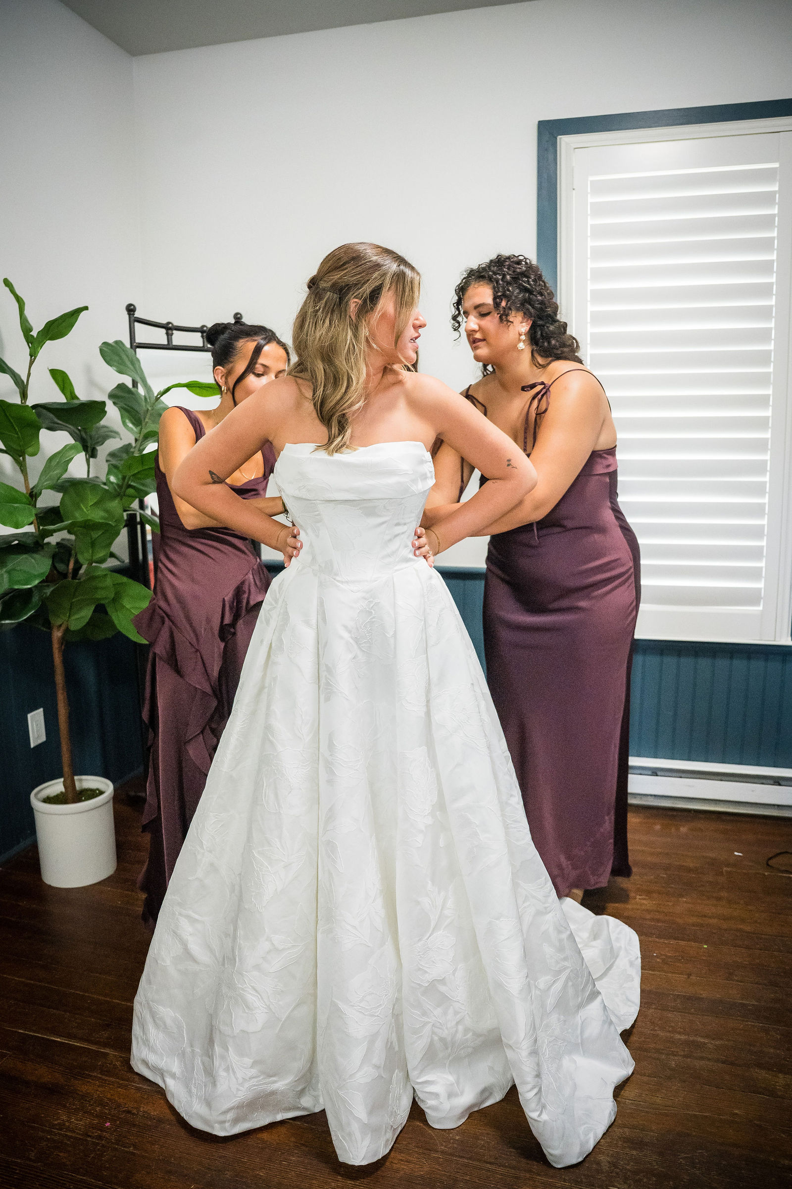 Helping the bride into her wedding dress