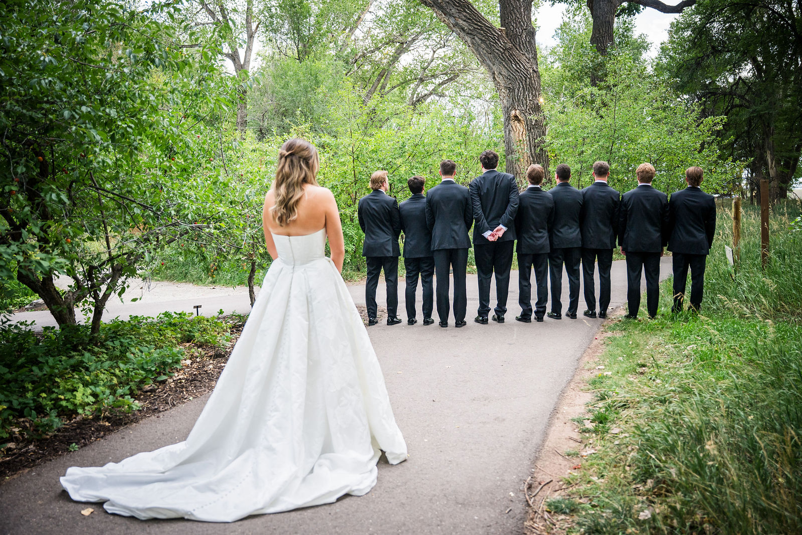 Bride walking up behind the groomsmen for a first look