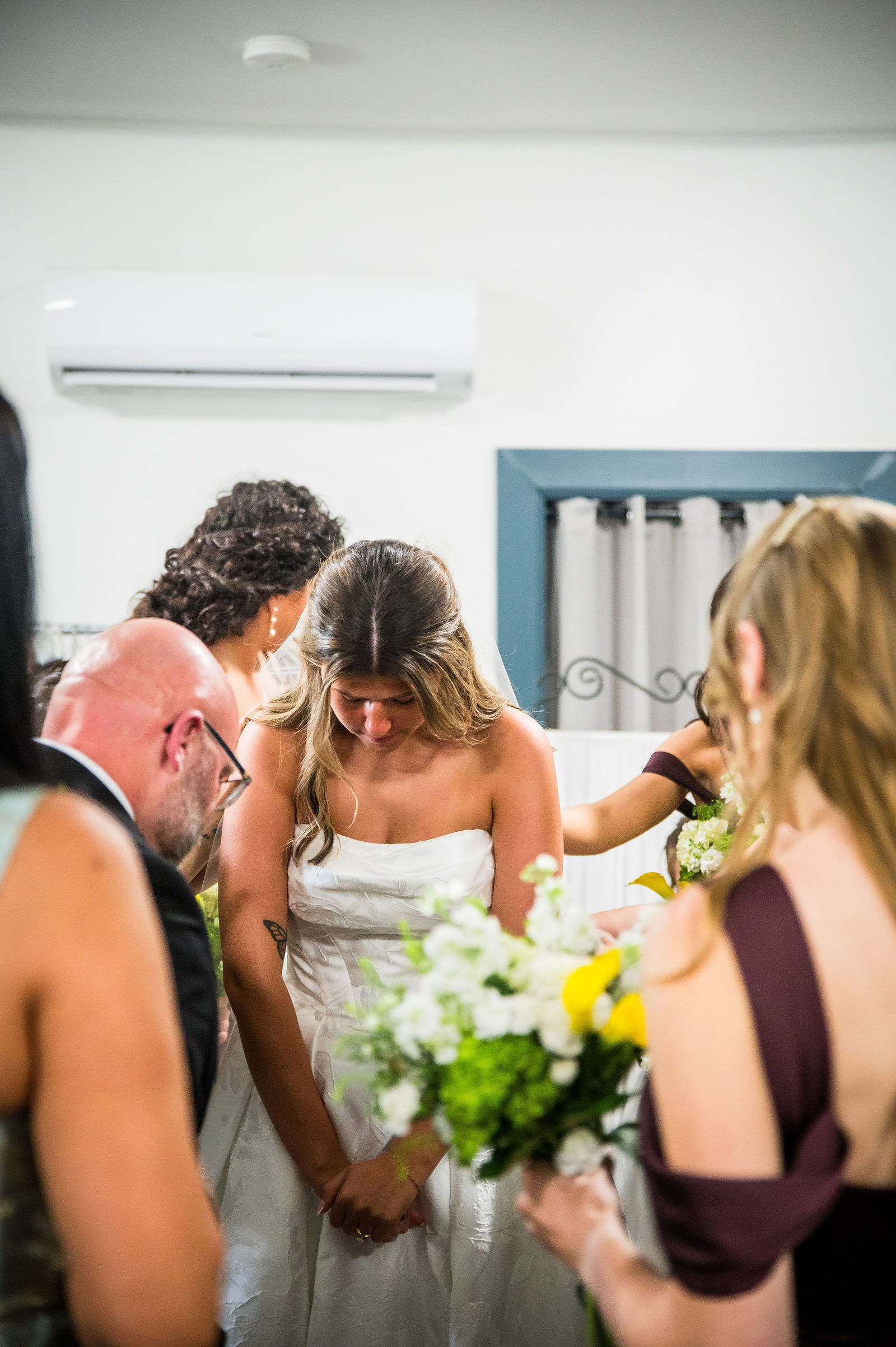 Family and friends praying together before a Colorado wedding