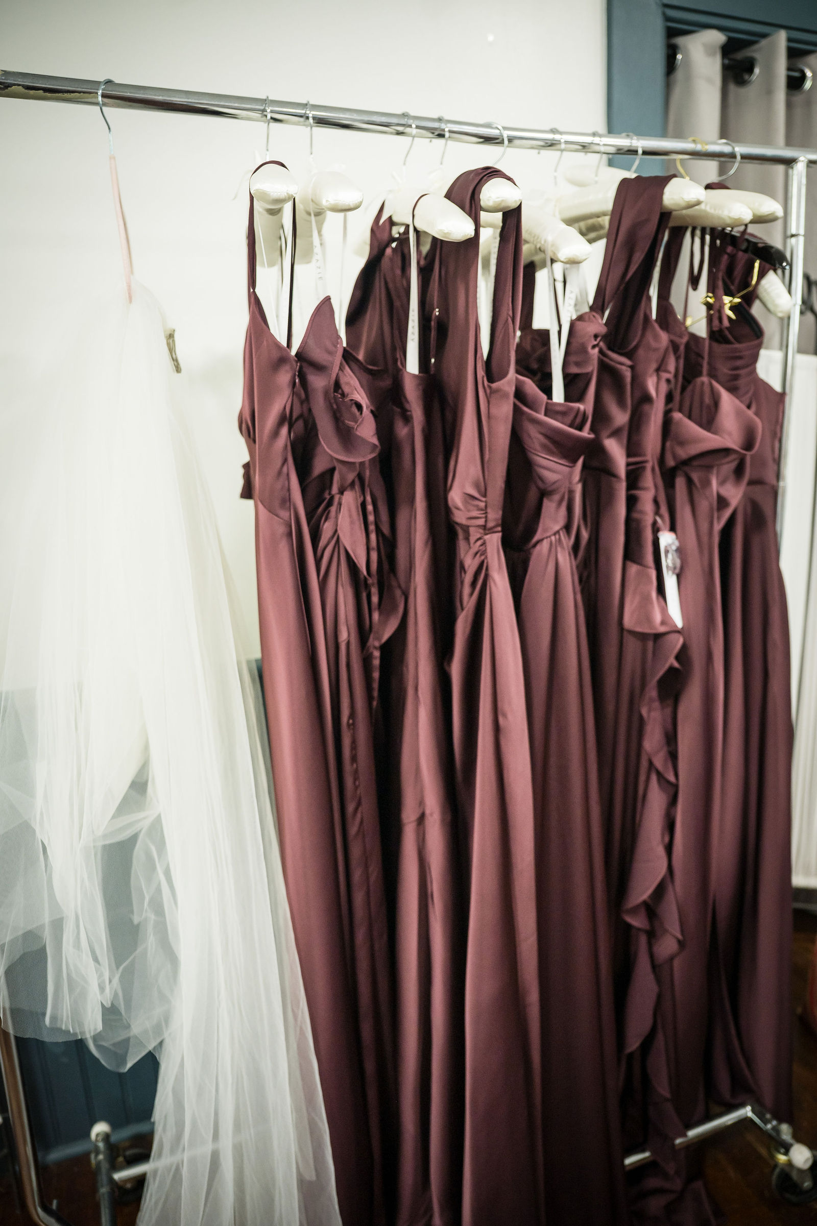 Deep plum bridesmaid dresses hanging before a Colorado wedding