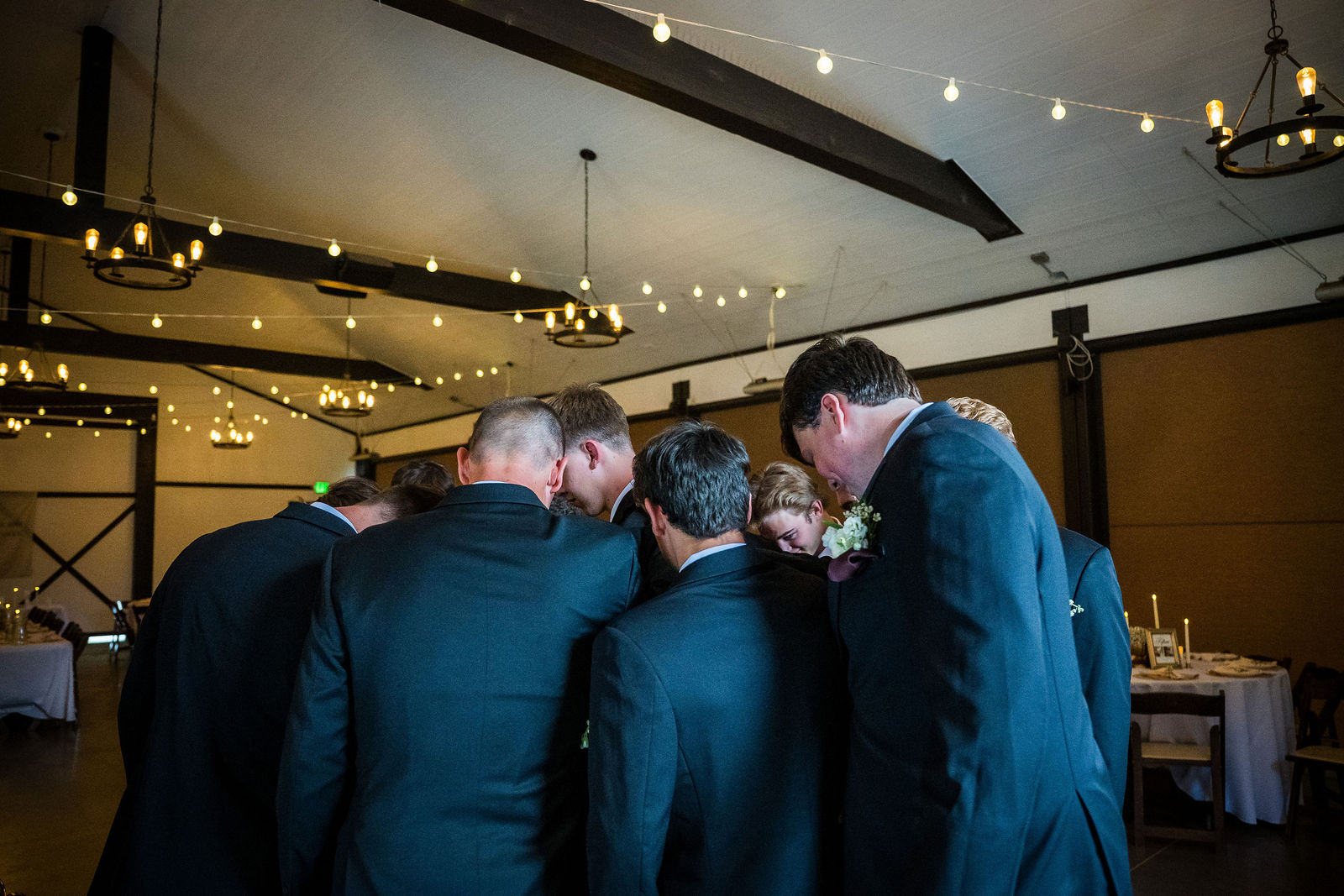 Groomsmen praying over the groom before the ceremony